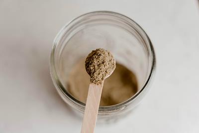 Image of a wooden spoon holding kief above a jar.