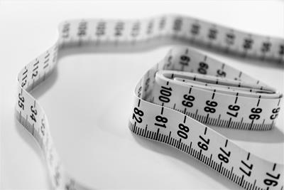 Image of a measuring tape on a grey surface.