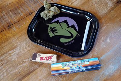 Rolling tray next to week and some rolling papers