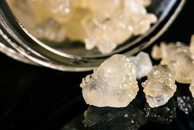 Full spectrum concentrate that has a light yellow color and structure like a diamond or gem that are poured out of a glass jar