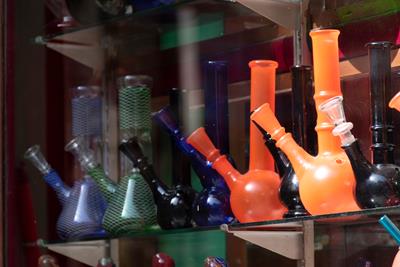 A wall of assorted and colorful glass bongs with different sizes and shapes. 