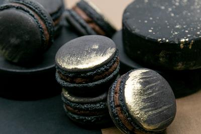 An image of an assortment of black and gold-dusted macarons.